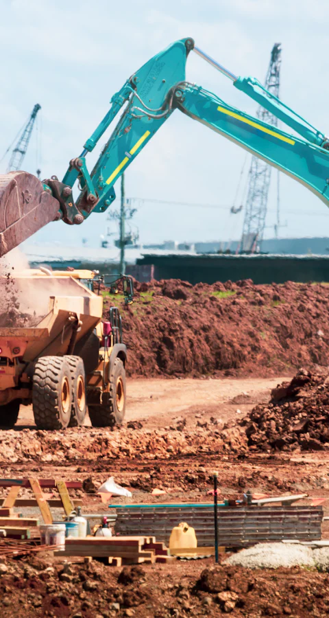 Bagger verlädt Erdaushub auf einen Muldenkipper auf einer Baustelle